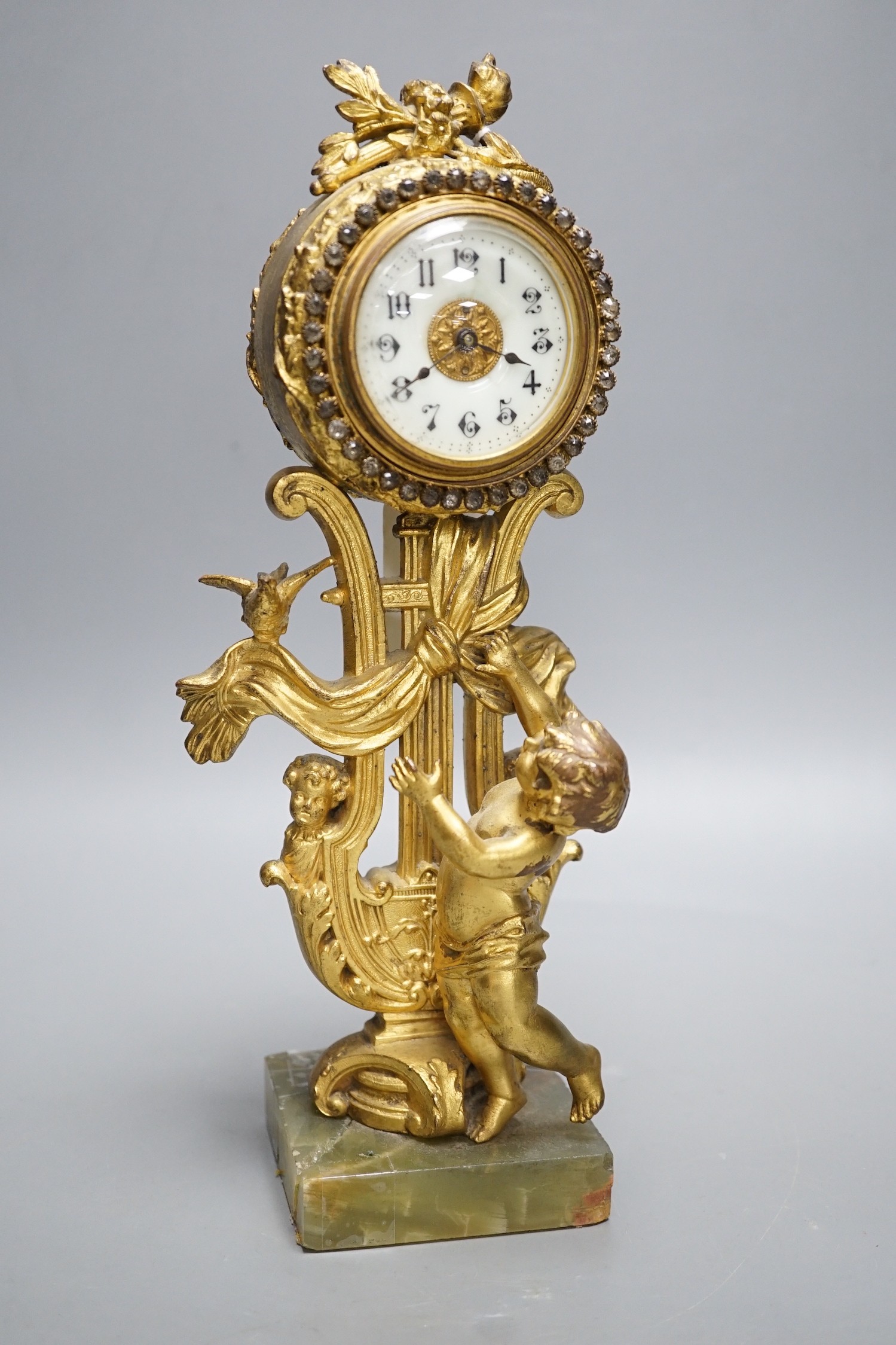 An early 20th century gilt metal cherubic mantel timepiece on onyx base, 29cm